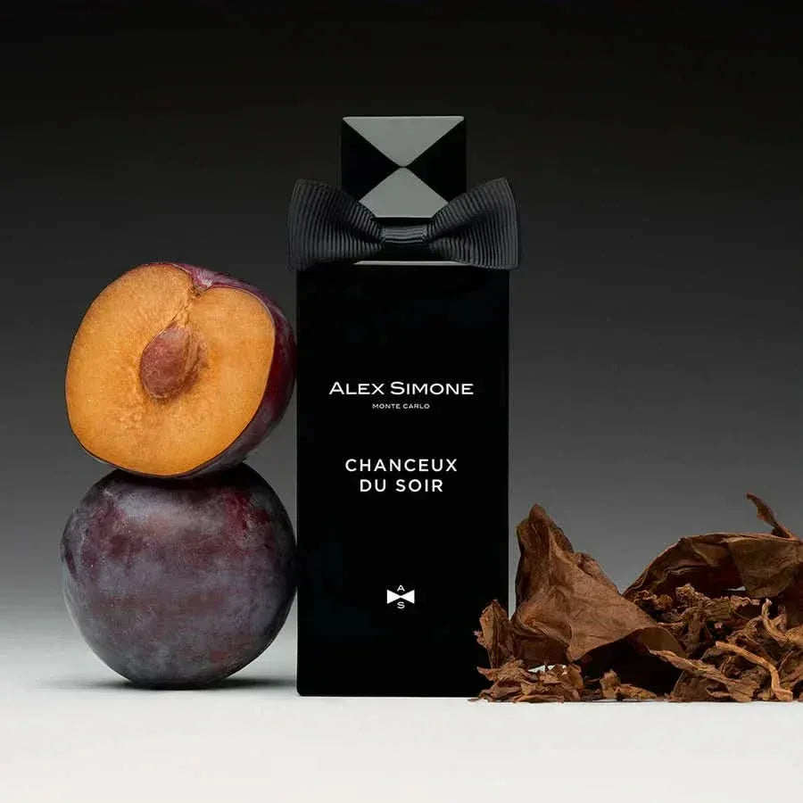 Czarny flakon perfum niszowych z nutami śliwki i tytoniu na ciemnym tle