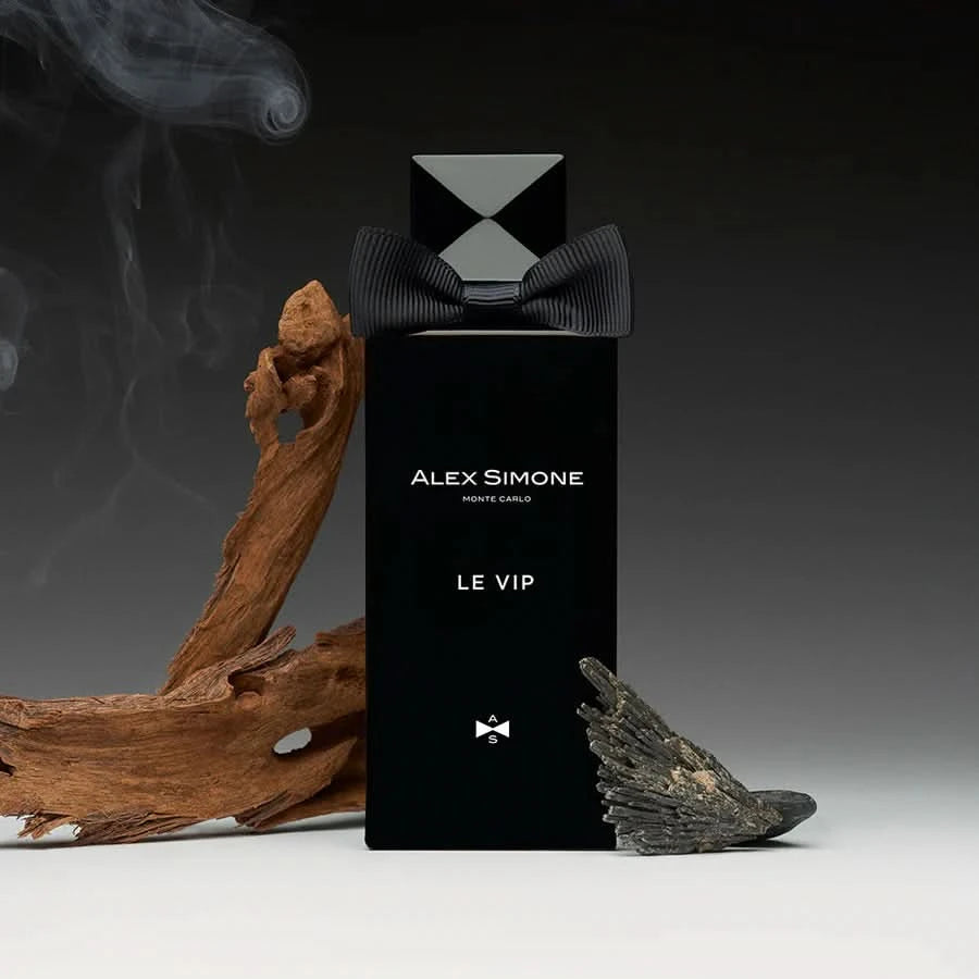 czarny flakon niszowych perfum Le VIP, ozdobiony muchą, na tle drewna, dymu i minerału